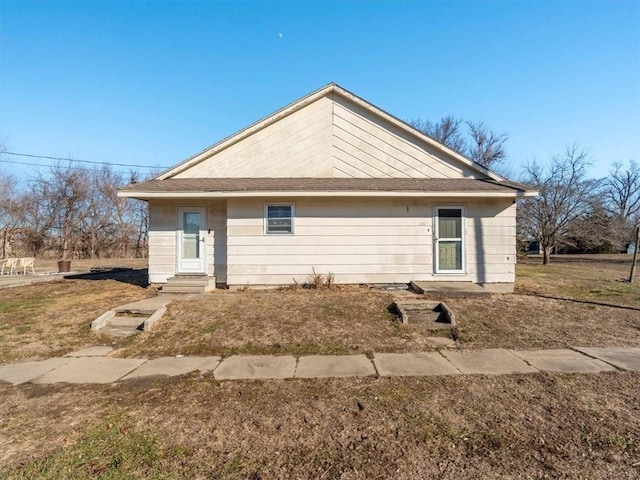 rear view of house featuring a yard