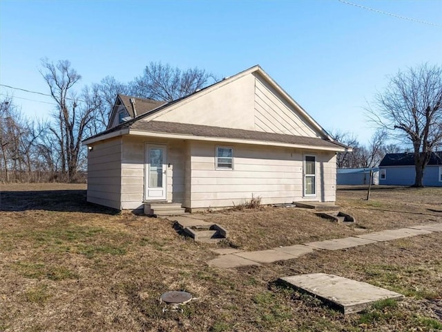 rear view of property featuring a yard