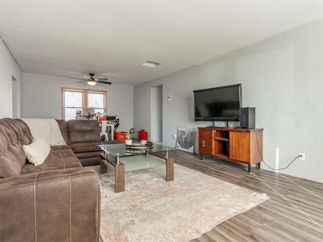 living room featuring hardwood / wood-style floors, a textured ceiling, and ceiling fan