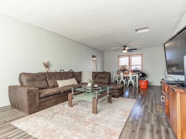 living room with ceiling fan and dark hardwood / wood-style flooring