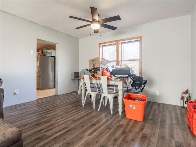 dining room featuring ceiling fan, dark wood-type flooring, and a textured ceiling