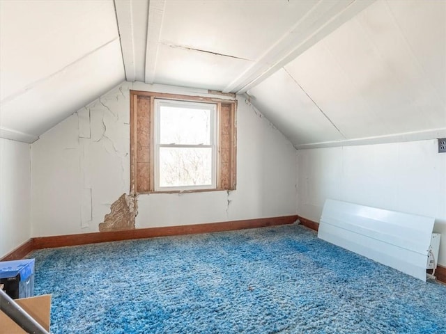 bonus room with lofted ceiling and carpet flooring