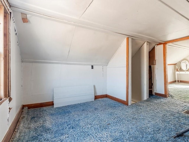 additional living space featuring lofted ceiling and carpet floors