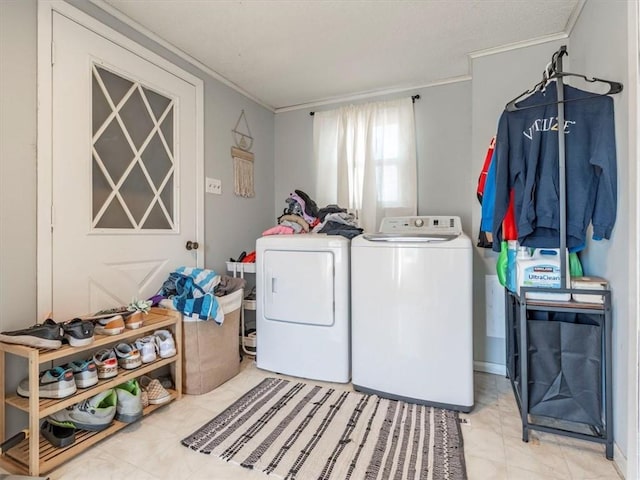 clothes washing area featuring crown molding and washer and clothes dryer