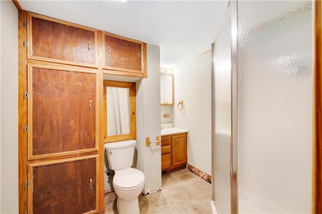 bathroom with vanity, toilet, and a shower with shower door