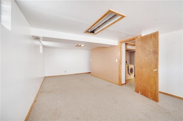 basement featuring washing machine and dryer and light carpet