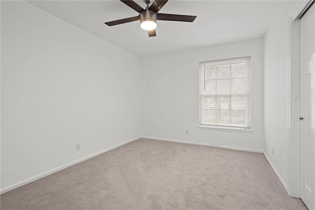 carpeted spare room featuring ceiling fan