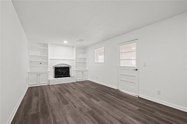 unfurnished living room featuring a fireplace, baseboards, dark wood finished floors, and built in features