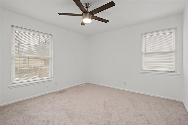 empty room featuring carpet, baseboards, and ceiling fan