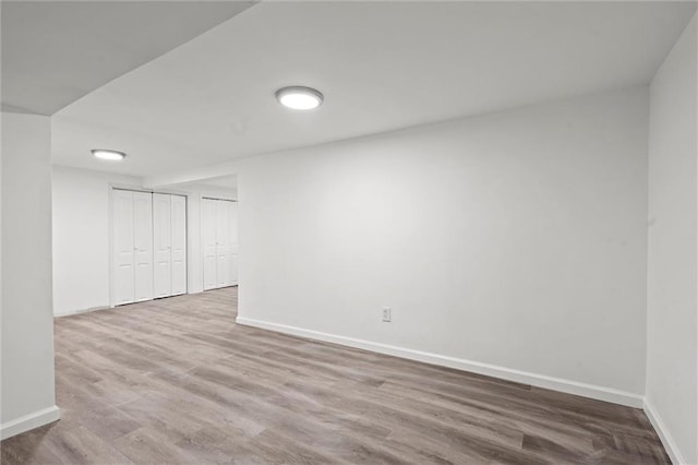 below grade area featuring wood finished floors and baseboards