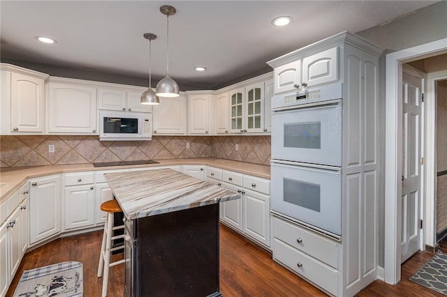 kitchen featuring white cabinetry, white appliances, and a center island