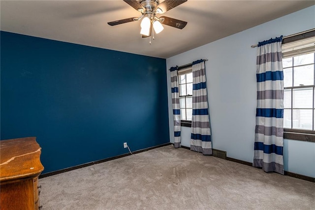 carpeted spare room with ceiling fan