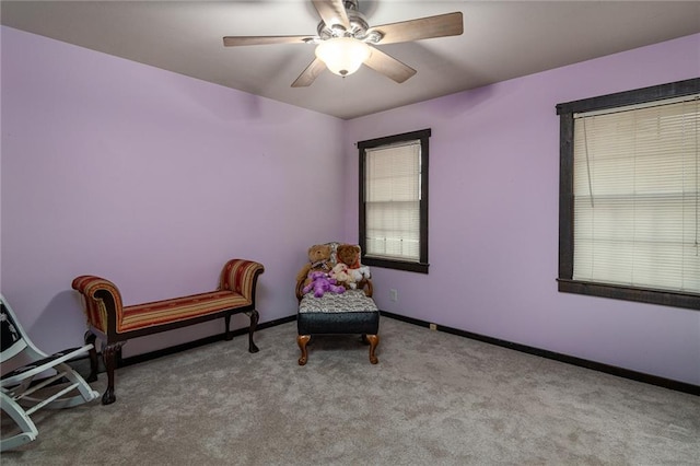 sitting room with ceiling fan and light carpet