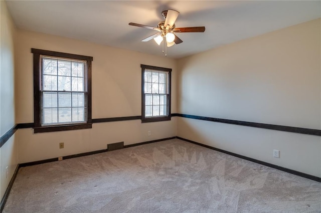 spare room featuring light carpet and ceiling fan