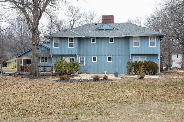 rear view of property featuring a lawn