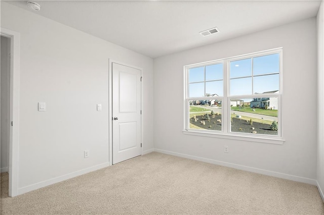 unfurnished room featuring light carpet