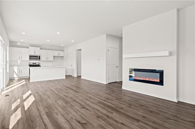 unfurnished living room with dark wood-type flooring