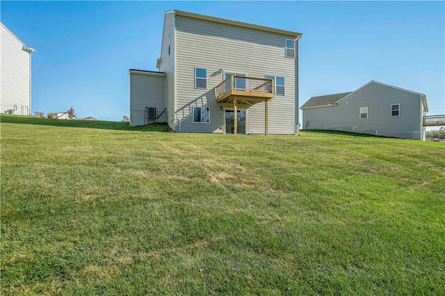 rear view of house featuring a lawn and a deck