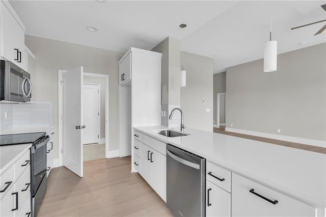 kitchen with stainless steel appliances, tasteful backsplash, a sink, and light countertops