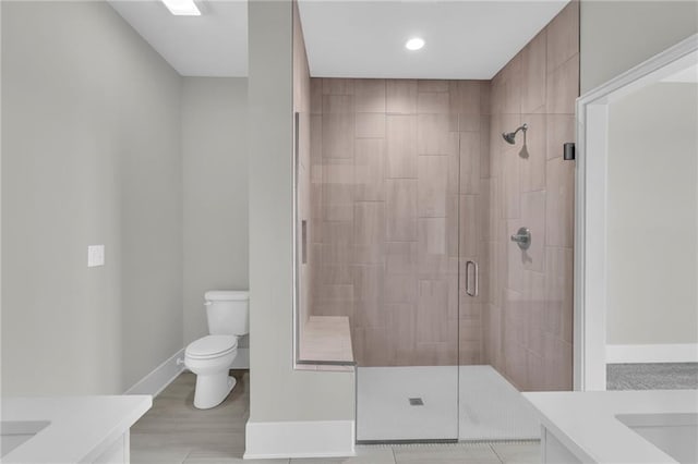 full bath featuring baseboards, a shower stall, toilet, and vanity