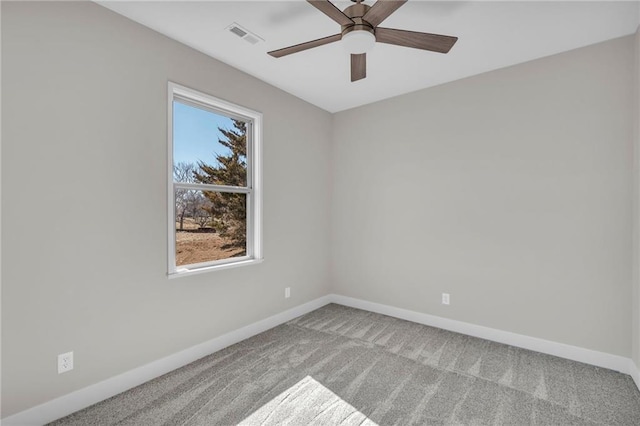 carpeted spare room with visible vents, baseboards, and ceiling fan