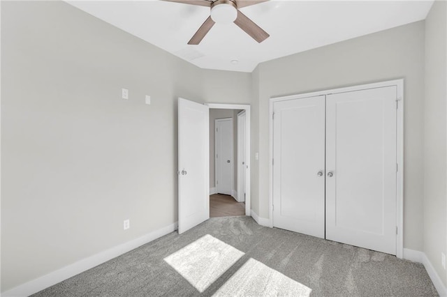 unfurnished bedroom featuring a ceiling fan, a closet, carpet flooring, and baseboards