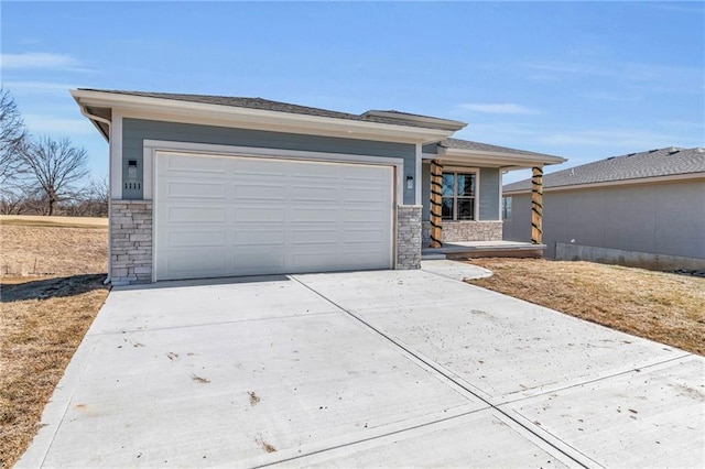 prairie-style home with stone siding, an attached garage, and concrete driveway