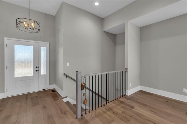 entryway featuring a notable chandelier, wood finished floors, and baseboards