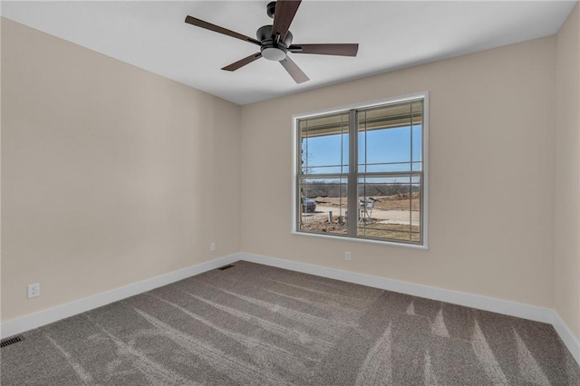 empty room featuring ceiling fan, dark colored carpet, and baseboards