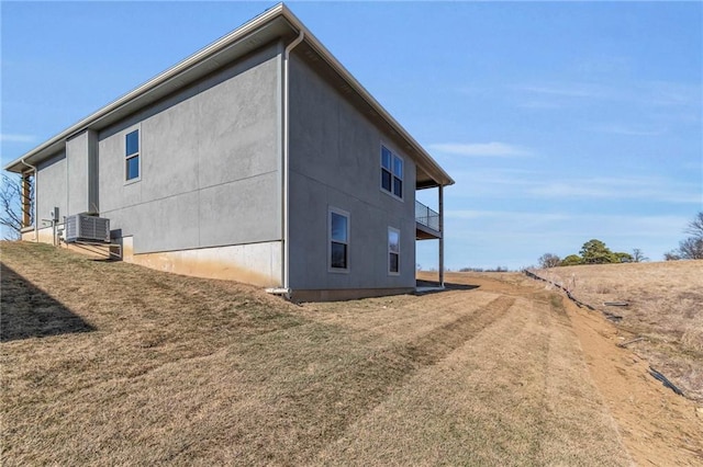 view of side of home featuring central air condition unit and a lawn