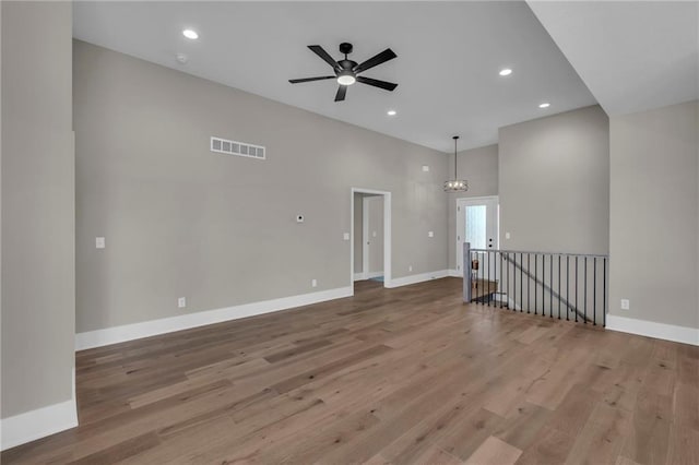 1111 Old Time Dr, Excelsior Springs, MO 64024 - unfurnished room with wood finished floors, ceiling fan with notable chandelier, baseboards, visible vents, and recessed lighting