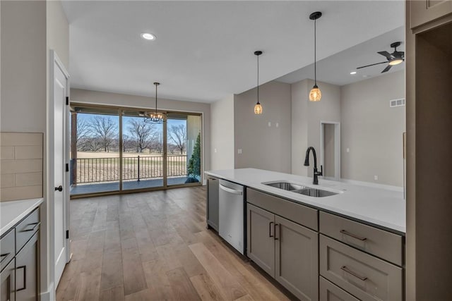 1111 Old Time Dr, Excelsior Springs, MO 64024 - kitchen featuring stainless steel dishwasher, a sink, ceiling fan with notable chandelier, gray cabinets, and light countertops