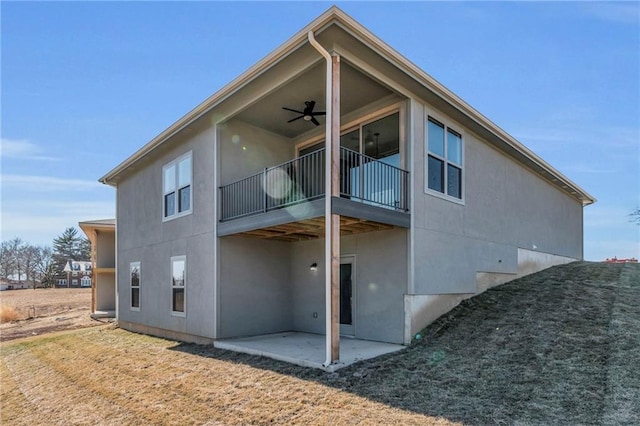 1111 Old Time Dr, Excelsior Springs, MO 64024 - rear view of property featuring stucco siding, a patio area, a lawn, and a ceiling fan