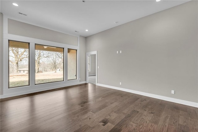 spare room with dark wood-style floors, recessed lighting, and baseboards