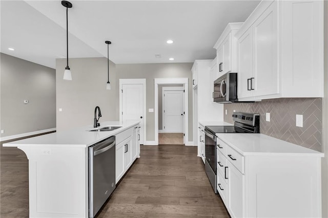 kitchen with dark wood finished floors, stainless steel appliances, light countertops, decorative backsplash, and a sink