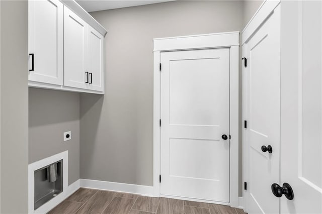 washroom with cabinet space, wood tiled floor, baseboards, and hookup for an electric dryer