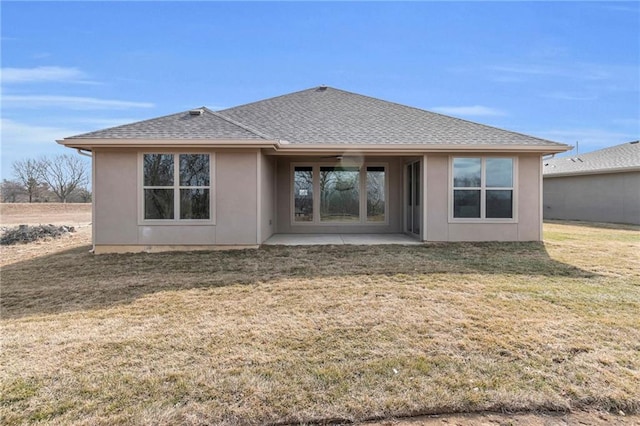 back of house with a patio, a shingled roof, and a lawn