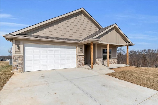 1112 Old Time Dr, Excelsior Springs, MO 64024 - view of front facade with a garage, a porch, stone siding, and concrete driveway