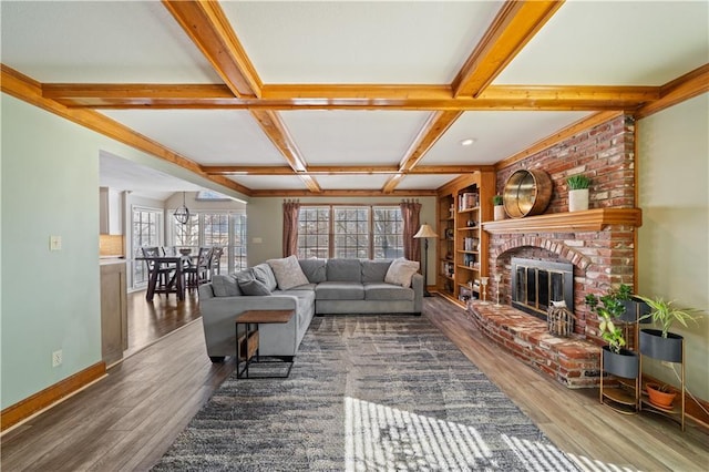 living room with a fireplace, beam ceiling, and dark wood-type flooring