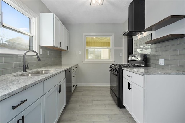 kitchen featuring white cabinetry, black range with gas stovetop, range hood, and sink