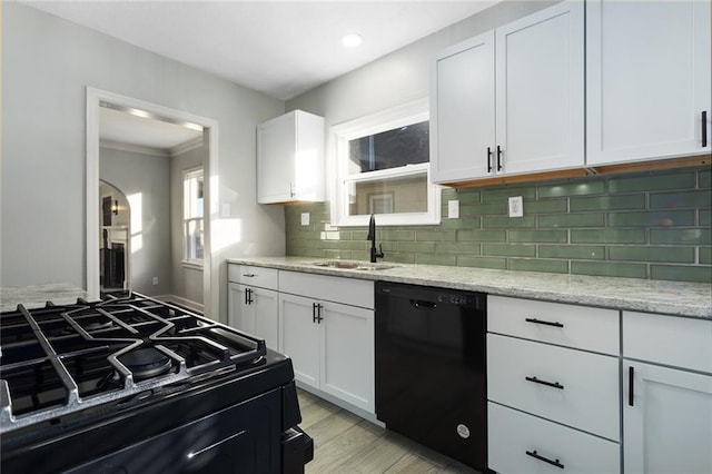 kitchen featuring gas stove, black dishwasher, sink, and white cabinets