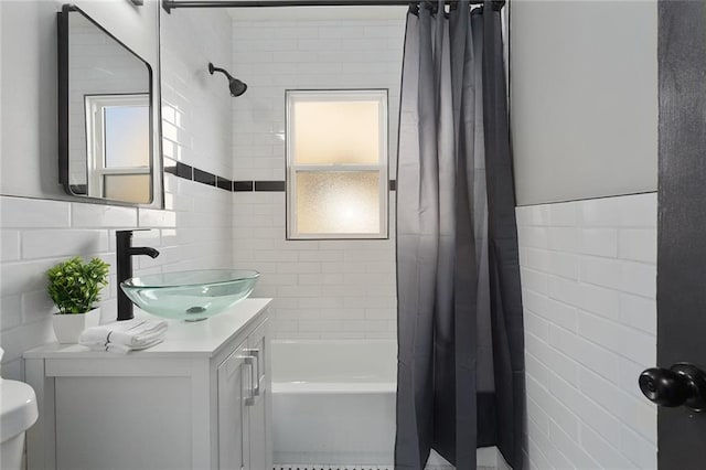 full bathroom with vanity, toilet, shower / tub combo, and tile walls