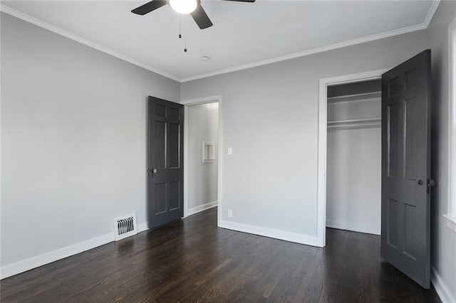 unfurnished bedroom with crown molding, dark wood-type flooring, ceiling fan, and a closet