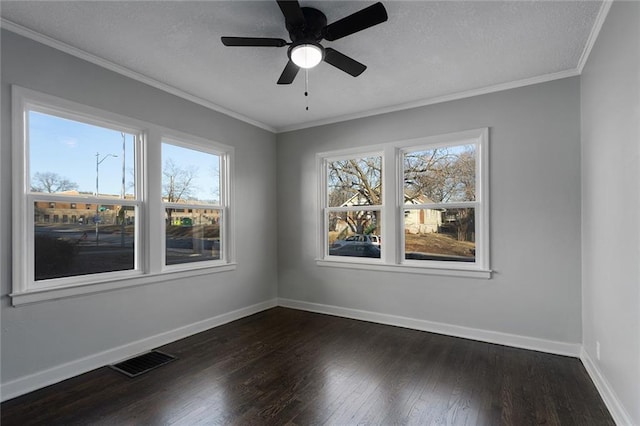 empty room with ornamental molding, a healthy amount of sunlight, ceiling fan, and dark hardwood / wood-style flooring