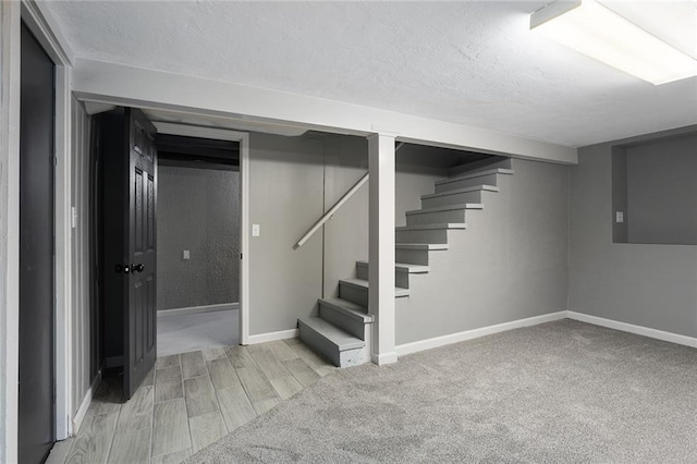 basement featuring a textured ceiling and light wood-type flooring