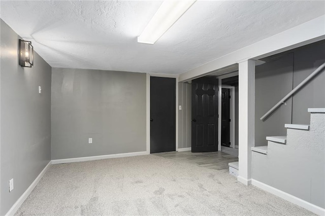 basement with light colored carpet and a textured ceiling