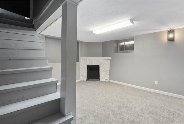 basement with a fireplace, a textured ceiling, and carpet