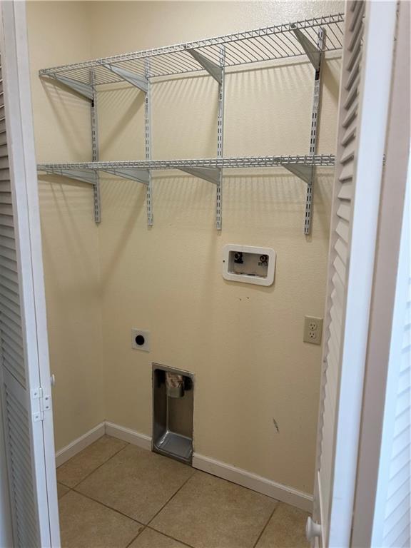 1202 NW County Road 6001, Butler, MO 64730 - laundry room featuring tile patterned flooring, hookup for a washing machine, electric dryer hookup, and baseboards