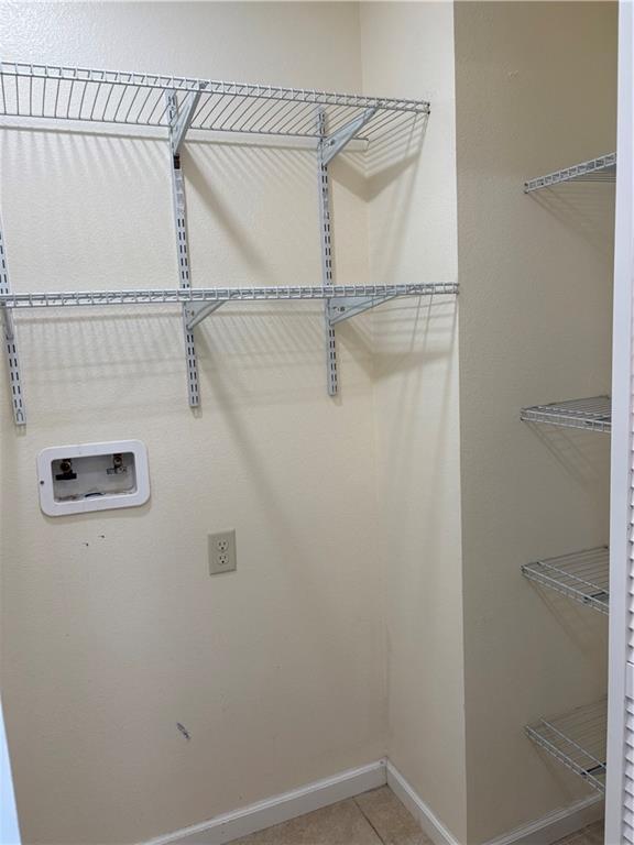 1202 NW County Road 6001, Butler, MO 64730 - laundry room featuring hookup for a washing machine, tile patterned floors, and baseboards