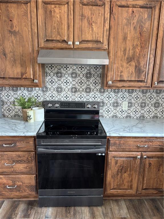 1202 NW County Road 6001, Butler, MO 64730 - kitchen with stainless steel electric range, extractor fan, tasteful backsplash, and dark wood finished floors